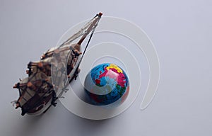 Blank for cards and backgrounds with a globe and a model of an old frigate on a white surface