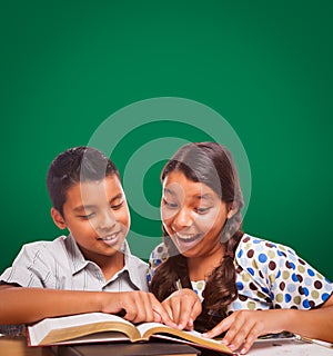 Blank Chalk Board Behind Hispanic Boy and Girl Having Fun Studying