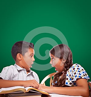 Blank Chalk Board Behind Hispanic Boy and Girl Having Fun Studying