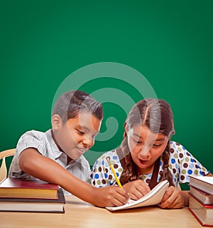 Blank Chalk Board Behind Hispanic Boy and Girl Having Fun Studying