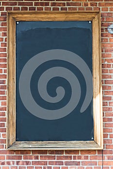 Blank chalkboard on brick wall