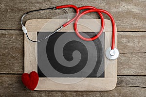 Blank chalkboard, stethoscope and red heart, health background c