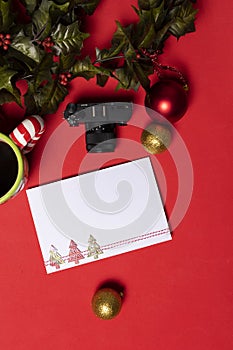 Blank christmas card on red table with small digital camera