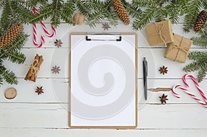 Blank clipboard and Christmas decoration on white wooden background. Flat lay, top view mock-up. To do