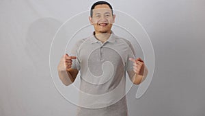 Blank collared shirt mock up template, front view, Asian male model wearing plain grey t-shirt isolated on white. Polo tee design