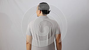 Blank collared shirt mock up template, rear back view, Asian male model wearing plain grey t-shirt isolated on white. Polo tee