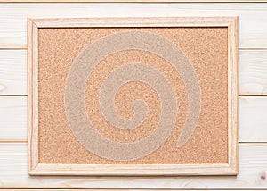 Blank cork board with corkboard texture background with wooden frame hanging on white wood wall for bullentin, memo or noticeboard