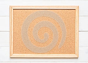 Blank cork board with corkboard texture background with wooden frame hanging on white wood wall for bullentin, memo or noticeboard