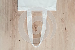 Blank cotton eco tote bag on wooden background, design mockup