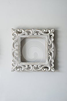 A blank decorative wooden photo frame on the wall.