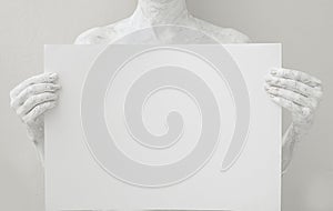 Blank design poster template. Woman covered with white paint holding a paper