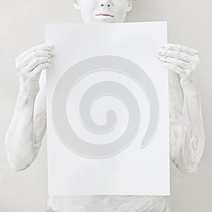 Blank design poster template. Woman covered with white paint holding a paper