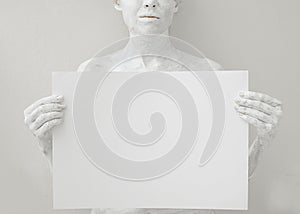 Blank design poster template. Woman covered with white paint holding a paper