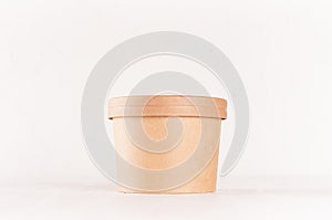 Blank disposable brown paper box for takeaway food - soup, salad, ice cream on white wood shelf closeup, mockup food packaging.