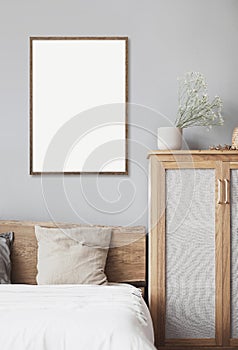 Blank empty picture frame mockup on gray wall in bedroom. Artwork in interior design.