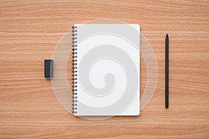 Blank empty ring binder notepad, pencil and black eraser on wooden table background copy space minimal style. Education