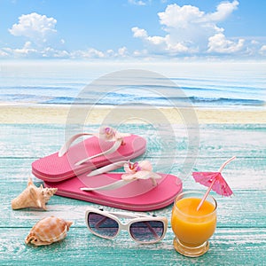 Blank empty tablet computer on beach. Trendy summer accessories on wooden background pool. Flip-flops on beach. Tropical flower or