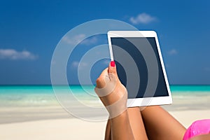Blank empty tablet computer in the hands of women on the beach
