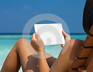 Blank empty tablet computer in the hands of women on the beach