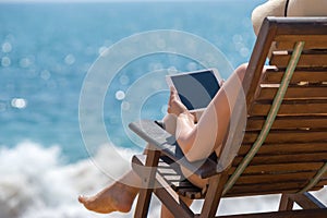 Blank empty tablet computer in the hands of women on the beach