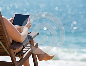 Blank empty tablet computer in the hands of women on the beach