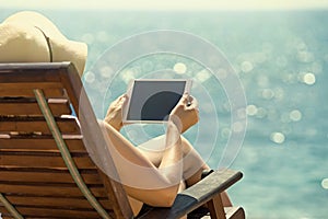 Blank empty tablet computer in the hands of women on the beach