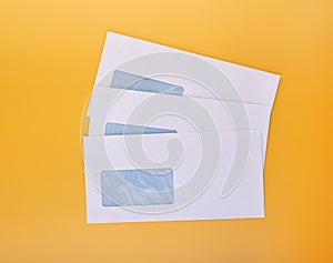 Blank envelopes with address window on yellow background. White paper envelopes mockup for business correspondence  postal