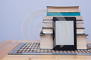 Blank eReader in front of a tower of books with bookmarks
