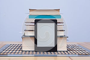 Blank eReader in front of a tower of books with bookmarks