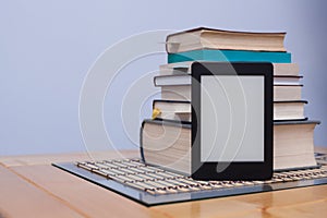 Blank eReader in front of a tower of books with bookmarks