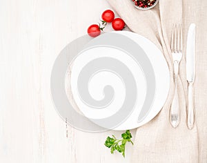 Blank flat plate, fork, knife on white table, top view. Mock up, copy space