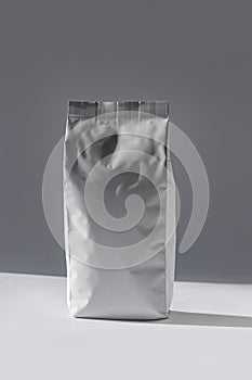 Blank foil food or drink bag on white background in minimal style, natural light shadow. Monochrome coffee pack flat lay