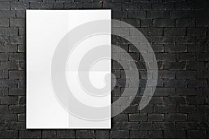 Blank folded paper poster hanging on black brick wall,Template m
