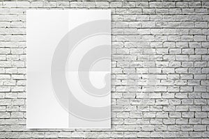 Blank folded paper poster hanging on white brick wall,Template m
