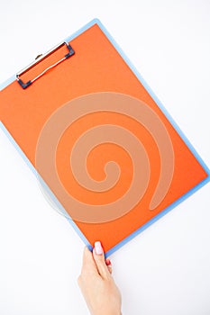 Blank Folder with ?range Paper. Hand that Holding Folder and Handle on White Background. Copyspace. Place for Text.