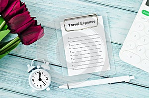 The Blank form travel expenses document with calculator, pen and clock on wooden floor