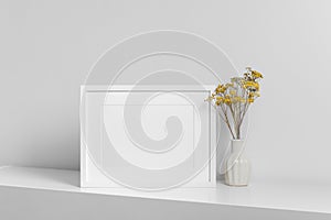 Blank frame mockup for artwork, photo or print presentation. White minimalistic interior with dry flowers