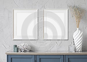 Blank frame mockup in modern interior design with blue sideboardand and flowers on empty gray wall background