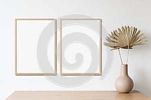 Blank frame mockup in modern interior design with vase and trendy plants on empty white wall background, Two vertical templates