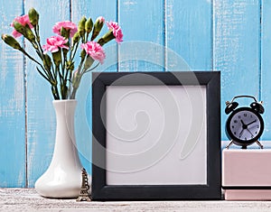 Blank frame, pink flowers, alarm clock and souvenir Eiffel tower