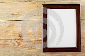 Blank frame on wooden background with sawdust.