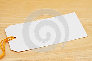 Blank gift tag with yellow ribbon on wood desk