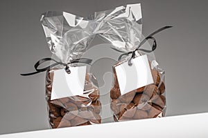 Blank gift tags with ribbon on two chocolate truffles bags