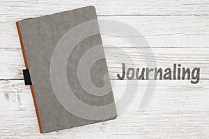 Blank gray journal on a weathered whitewash wood background