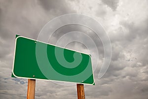 Blank Green Road Sign Over Storm Clouds