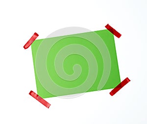 Blank green sheet of paper stuck with red sticky tape