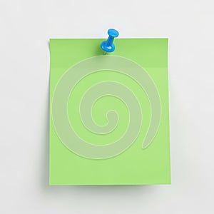 Blank green sticky note pinned to a white wall