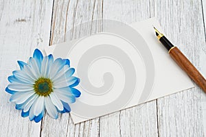 Blank greeting card with a flower and calligraphy pen
