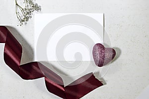 Blank greeting card, flyer or invitation card mockup with Valentines or women\'s day hearts and gypsophila, red ribbon