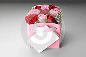 Blank greeting card over box of roses